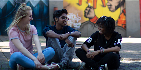 Three students sitting on ground and talking ? Shivan Parusnath